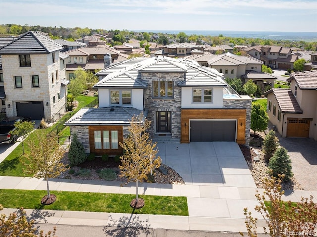 2136 S Juniper St, Lakewood, CO 80228 - contemporary house featuring stone siding, a residential view, driveway, stucco siding, and a garage