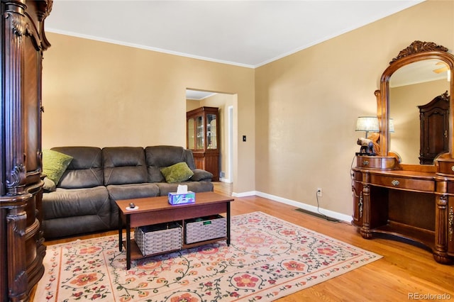 living room with ornamental molding, baseboards, and wood finished floors