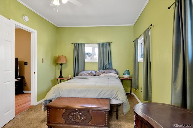 carpeted bedroom featuring baseboards, ornamental molding, and ceiling fan