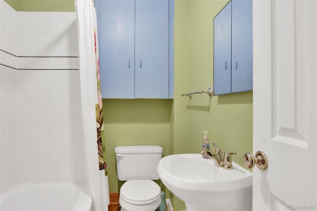 bathroom featuring a sink, toilet, and shower / tub combo with curtain