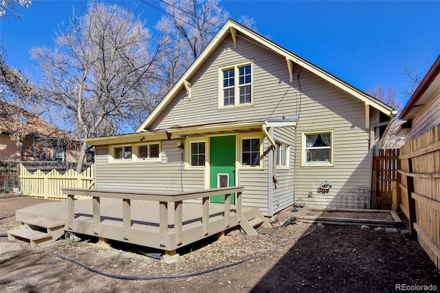 rear view of property featuring fence and a wooden deck