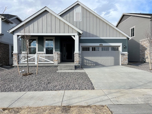 craftsman-style home featuring driveway, stone siding, a porch, board and batten siding, and an attached garage