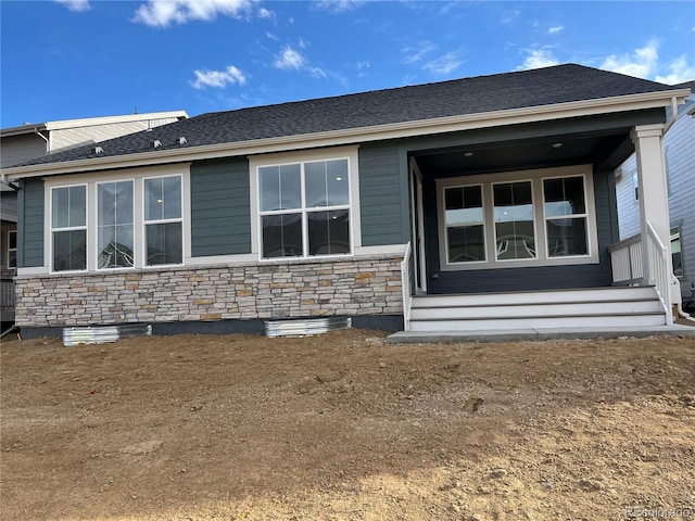 back of house featuring stone siding