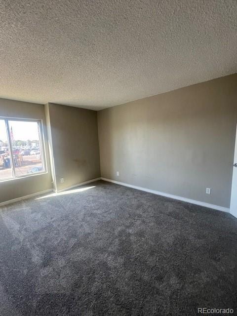 carpeted spare room featuring a textured ceiling