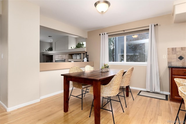 dining area with baseboards and light wood-style flooring