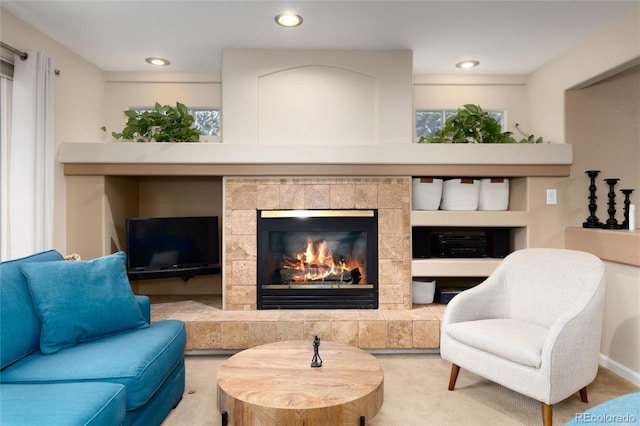 living area with a tiled fireplace, recessed lighting, and carpet