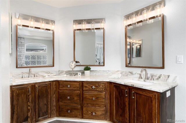 full bathroom with a sink and double vanity
