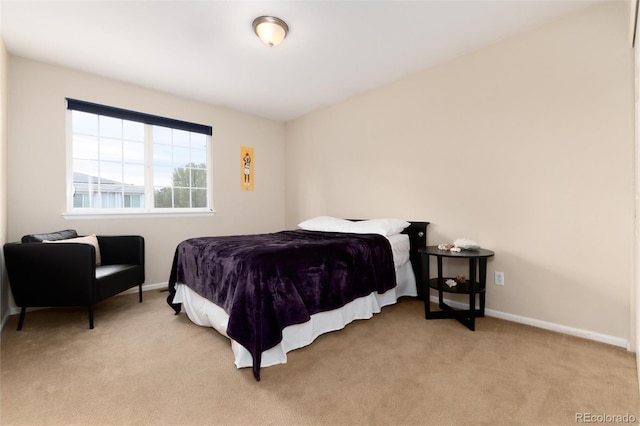 bedroom with baseboards and light carpet