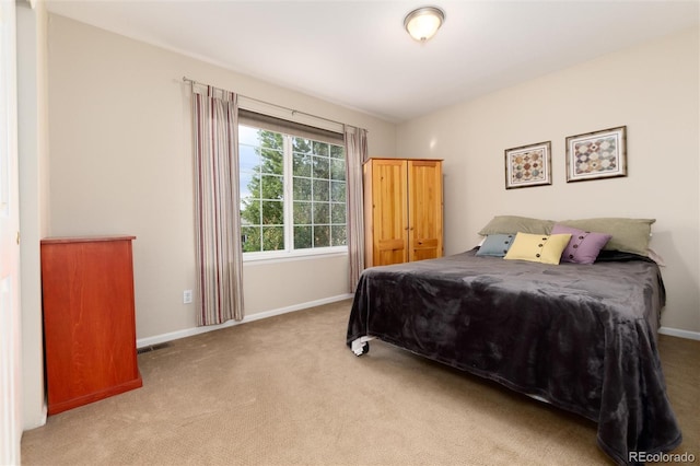 carpeted bedroom featuring baseboards and visible vents