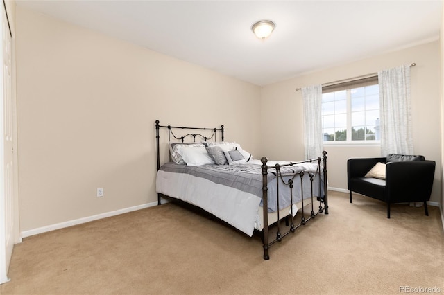 bedroom featuring baseboards and light carpet