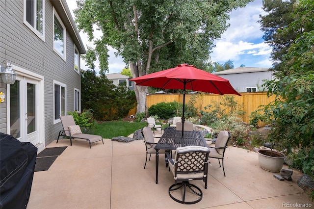 view of patio featuring outdoor dining area, a fenced backyard, and a grill