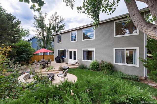 back of property with fence, a patio area, and french doors
