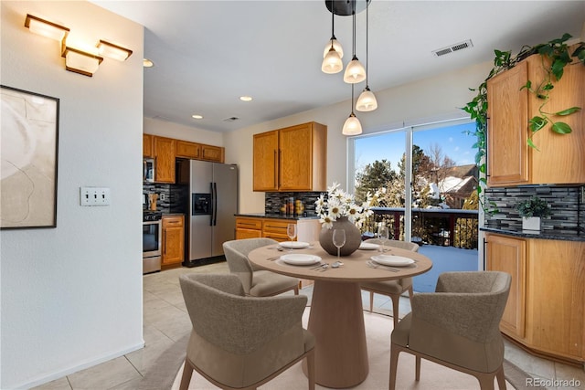 kitchen featuring pendant lighting, light tile patterned floors, tasteful backsplash, and stainless steel appliances