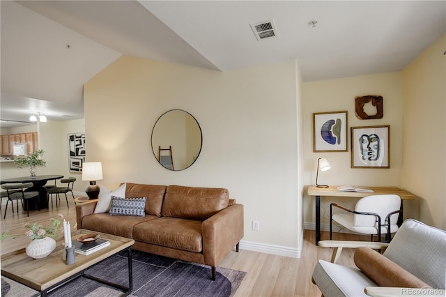 living area featuring visible vents, baseboards, and light wood-style flooring