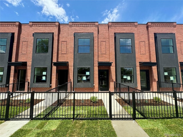 115 W 2nd Ave Unit 104, Denver, CO 80223 - townhome / multi-family property with brick siding, a fenced front yard, and a gate