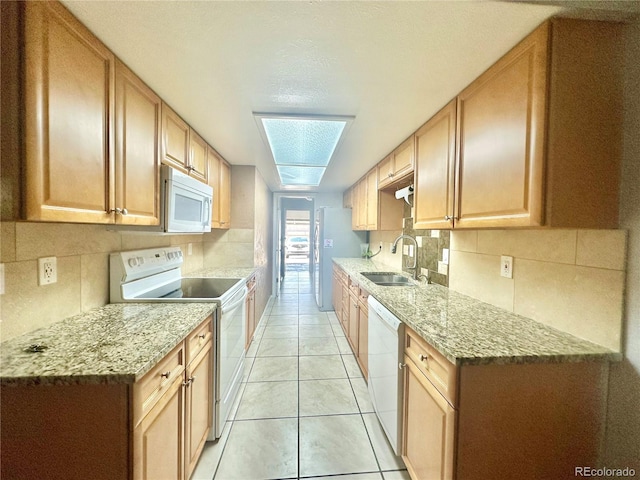 kitchen featuring decorative backsplash, white appliances, sink, and light tile patterned floors