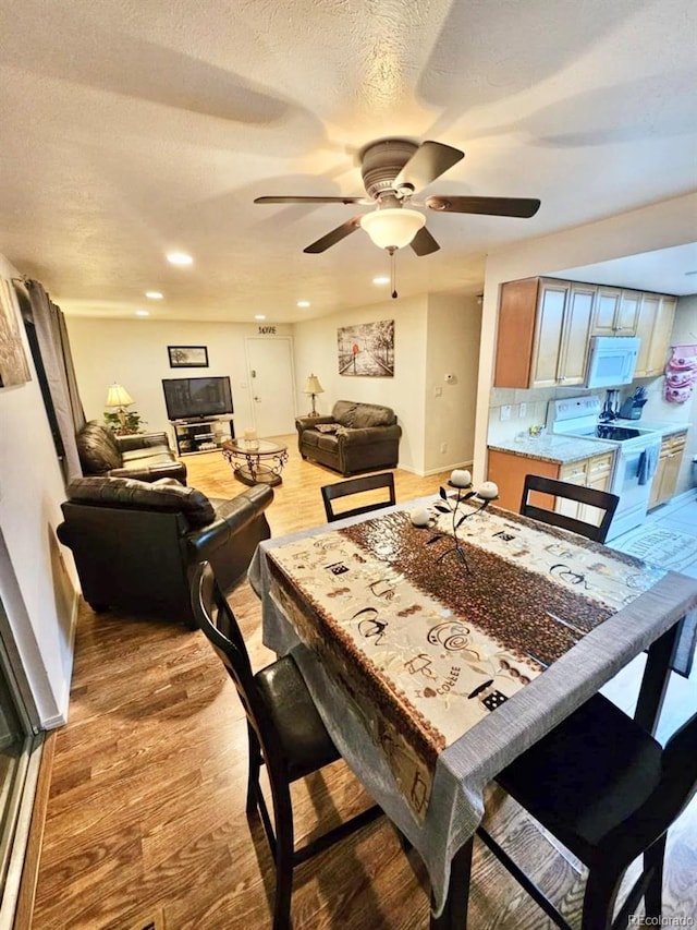 dining area with ceiling fan, a textured ceiling, and light wood-type flooring