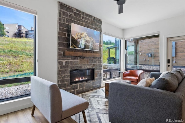 living room with a fireplace, light hardwood / wood-style floors, and ceiling fan