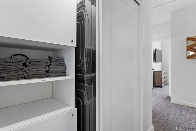 washroom with carpet, cabinets, and stacked washing maching and dryer