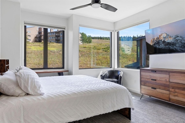 bedroom featuring carpet flooring, ceiling fan, and multiple windows