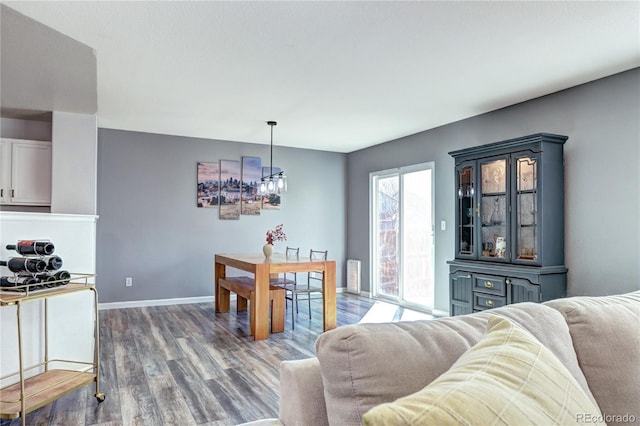 dining area with dark wood-type flooring and baseboards