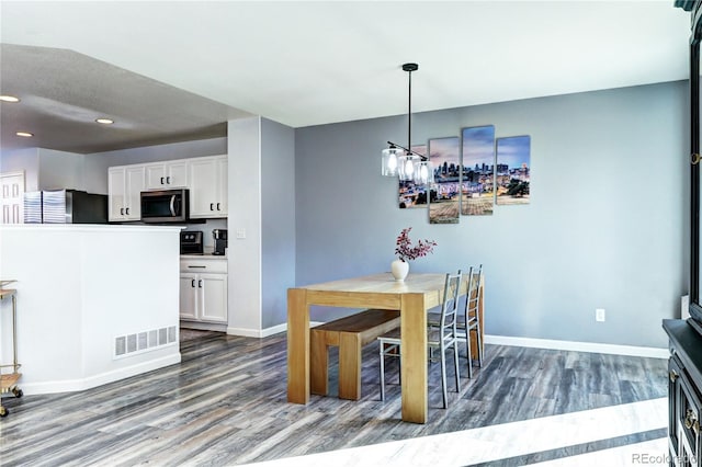 dining space with dark wood-type flooring, visible vents, and baseboards