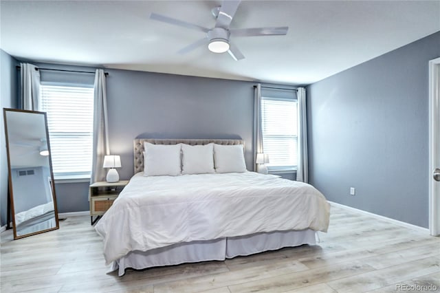 bedroom with baseboards, ceiling fan, and light wood finished floors