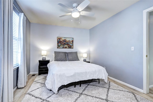 bedroom featuring light wood-style floors, ceiling fan, and baseboards