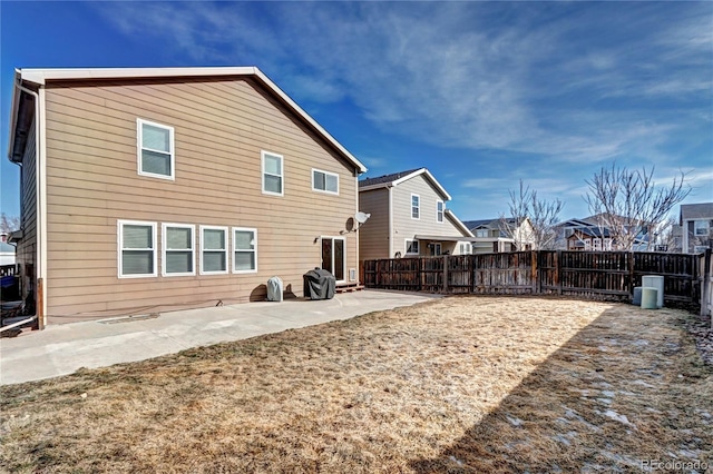 back of house featuring a patio, a yard, a fenced backyard, and a residential view