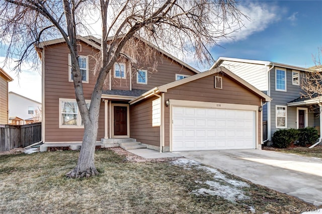 traditional-style home with driveway, an attached garage, fence, and a front yard