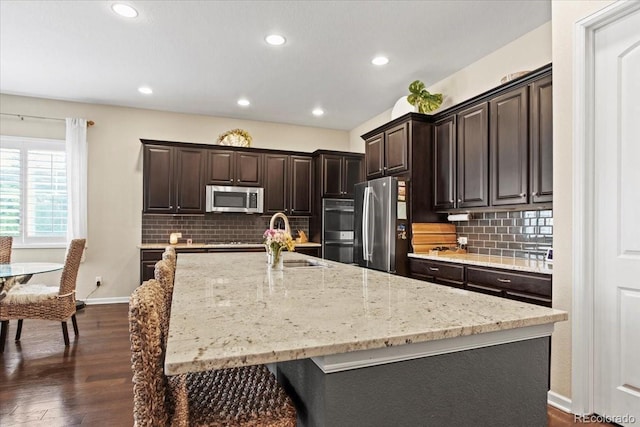 7790 S Queensburg Way, Aurora, CO 80016 - kitchen with stainless steel appliances, backsplash, dark wood-style flooring, dark brown cabinets, and recessed lighting