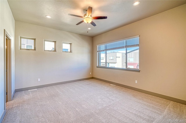 carpeted spare room featuring ceiling fan and a textured ceiling