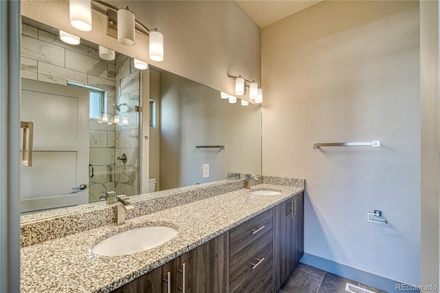 bathroom featuring a shower with door, vanity, and toilet