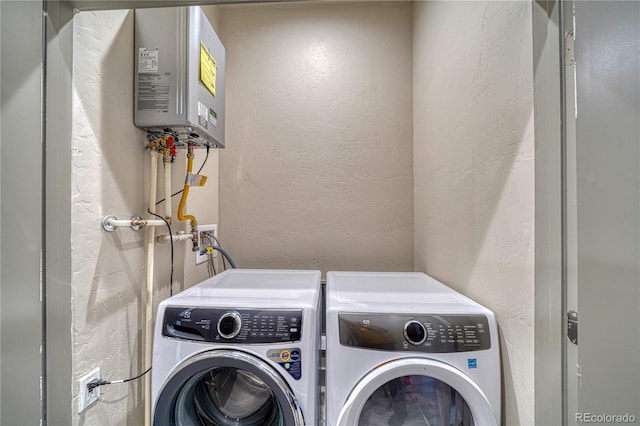 laundry room with water heater and washer and dryer