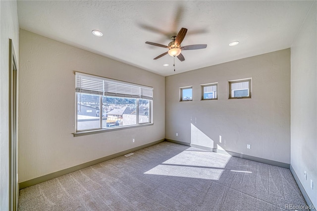 carpeted empty room with a textured ceiling and ceiling fan