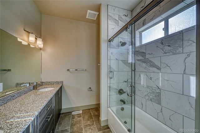 bathroom with vanity and shower / bath combination with glass door