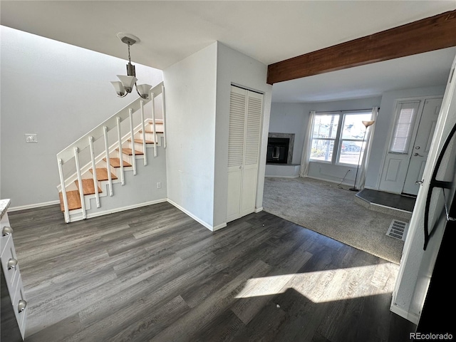 foyer featuring beam ceiling, dark hardwood / wood-style floors, and an inviting chandelier