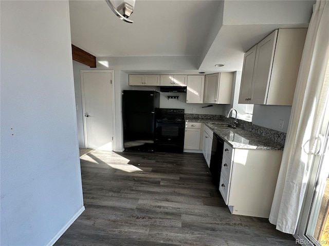 kitchen featuring dark hardwood / wood-style flooring, dark stone counters, sink, black appliances, and white cabinetry