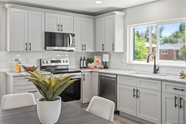 4903 W 11th Ave, Denver, CO 80204 - kitchen featuring stainless steel appliances, backsplash, healthy amount of natural light, and recessed lighting