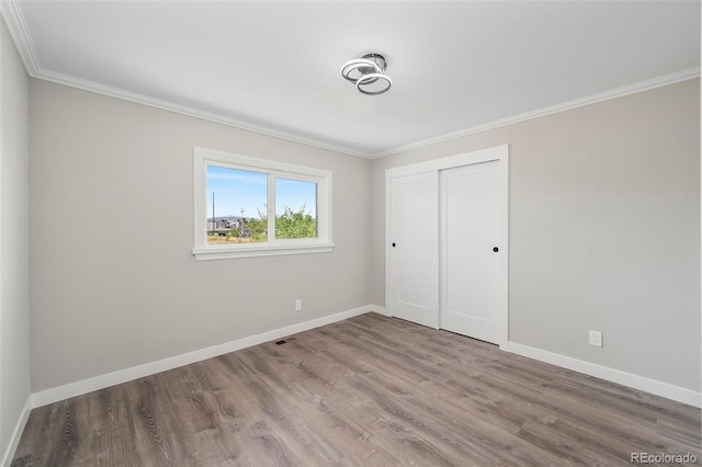 4903 W 11th Ave, Denver, CO 80204 - unfurnished bedroom with crown molding, wood finished floors, and a closet