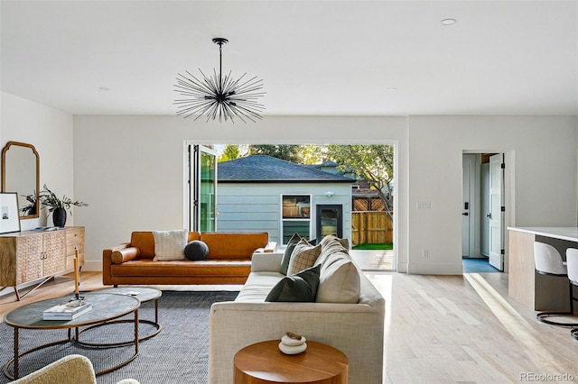 2391 Hudson St, Denver, CO 80207 - living area with light wood-style flooring, a chandelier, and baseboards