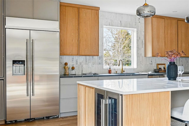 2391 Hudson St, Denver, CO 80207 - kitchen featuring built in refrigerator, wine cooler, decorative backsplash, light wood-type flooring, and light countertops