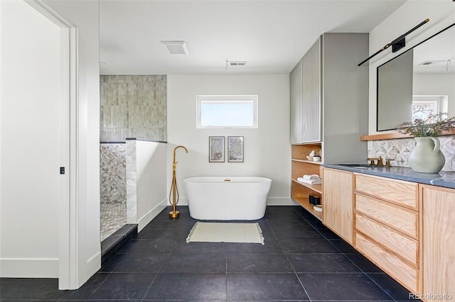 2391 Hudson St, Denver, CO 80207 - full bathroom with vanity, a soaking tub, tile patterned flooring, backsplash, and baseboards