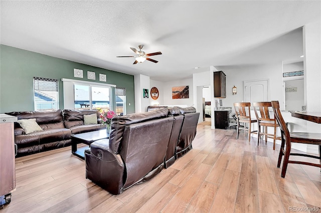 living room with ceiling fan and light wood finished floors