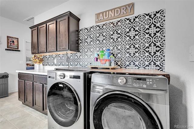 washroom with washing machine and dryer, cabinet space, and light tile patterned floors