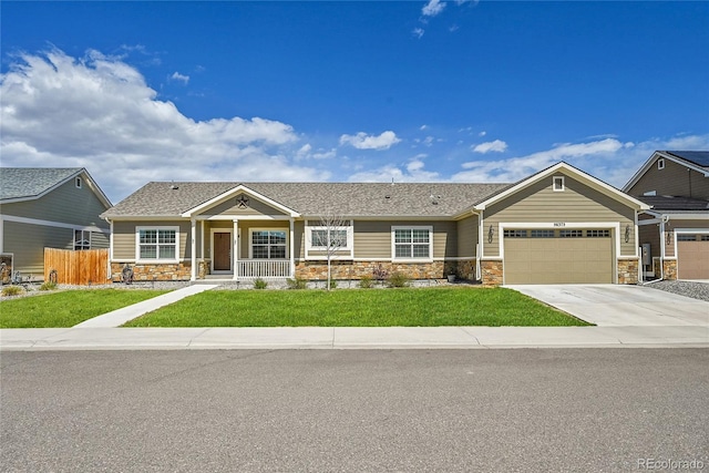 56375 E 22nd Pl, Strasburg, CO 80136 - view of front of home featuring stone siding, covered porch, an attached garage, and concrete driveway