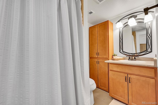 bathroom with tile patterned flooring, toilet, vanity, and visible vents