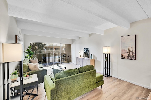 living room with beamed ceiling, light wood-style floors, baseboards, and a textured ceiling