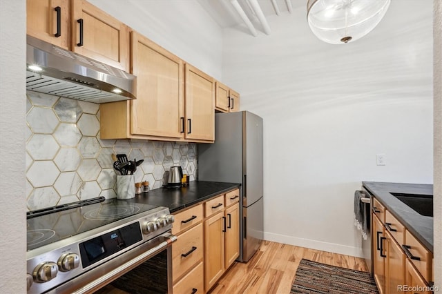 kitchen featuring baseboards, light wood-style floors, under cabinet range hood, appliances with stainless steel finishes, and tasteful backsplash