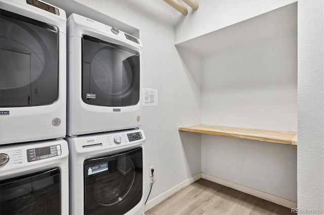 clothes washing area with light hardwood / wood-style flooring and stacked washing maching and dryer